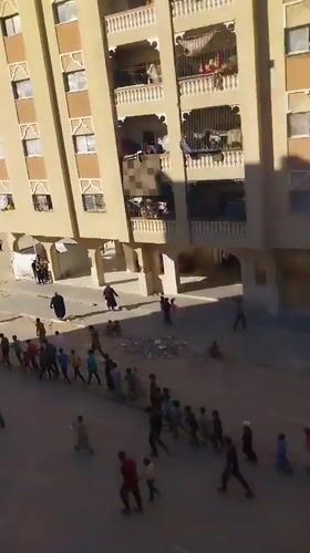 Children walk in supervised group through Khan Yunis streets
