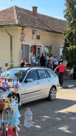 Brass musicians perform on building steps in Bulgarian village