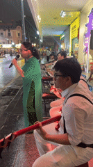 Live street band performs on a rainy Hanoi night