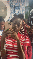 Young person takes selfie during hair appointment in Nigeria