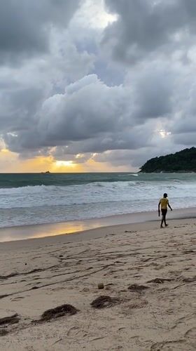 Dramatic sunset breaks through storm clouds at Thai beach