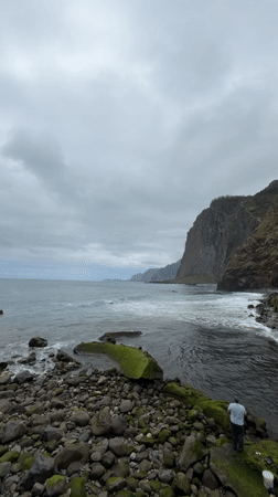 Man contemplates ocean from rocky shore in Santana
