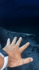 Smartwatch wearer captured on video near nighttime ocean waves