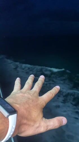 Smartwatch wearer captured on video near nighttime ocean waves