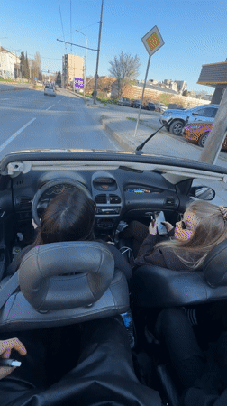 Two women cruise in white convertible through Varna