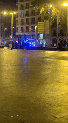 Nighttime skateboarding observed in wet Barcelona plaza