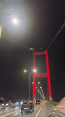 Evening traffic crosses red-lit bridge in Istanbul's Beşiktaş district