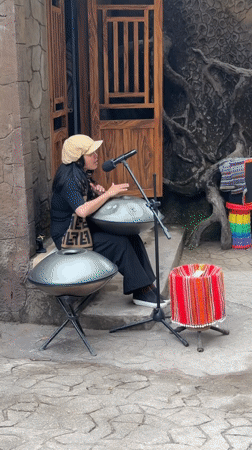 Street musician performs handpan at dawn in Da Lat