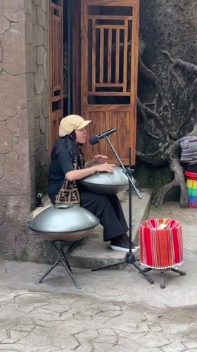 Street musician performs handpan at dawn in Da Lat