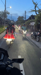 Scooter convoy recorded on Ubud road at dusk