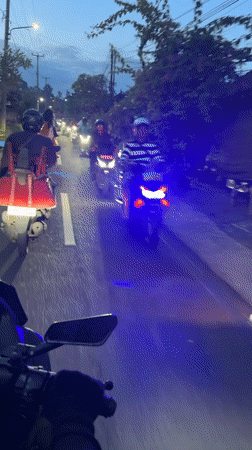 Scooter convoy recorded on Ubud road at dusk