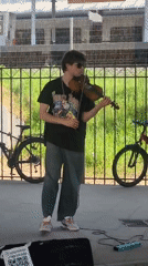 Street musician busks with electric violin outside Moscow station