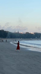 Kuta Beach at golden hour, people, shoreline, and Bali landmarks