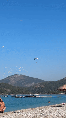 Paragliders, boats, and beach life on a Fethiye summer morning