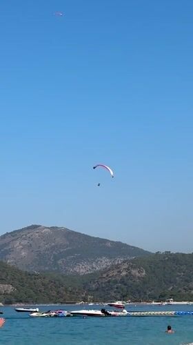 Paragliders, boats, and beach life on a Fethiye summer morning