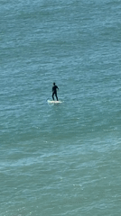 Busy beach day with paddleboarding and sunbathing in Ericeira