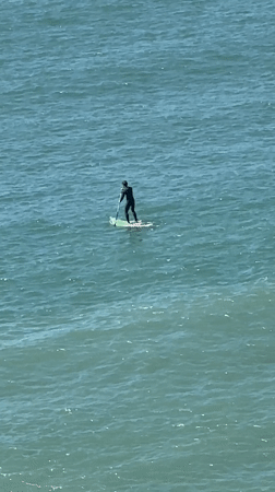 Busy beach day with paddleboarding and sunbathing in Ericeira