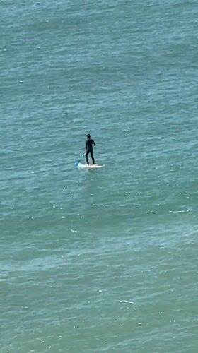 Busy beach day with paddleboarding and sunbathing in Ericeira