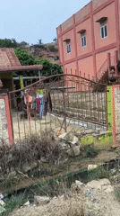 Excavator works hillside near homes in Lhokseumawe, Indonesia