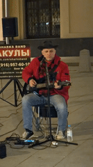 Street musician performs guitar on Moscow sidewalk