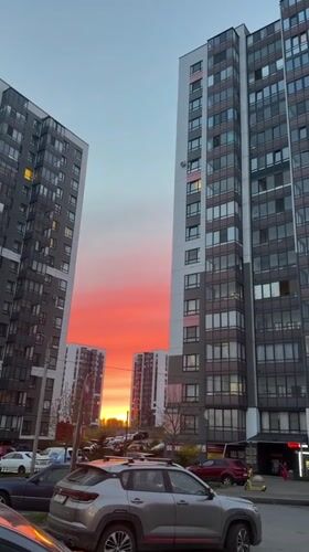 Vivid sunset captured between apartment buildings in Koltushi, Russia