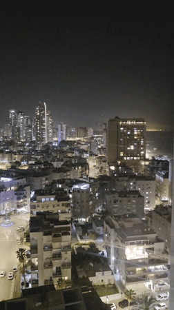 Evening aerial views document Bat Yam cityscape and coastline