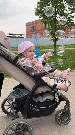 Child plays with bubbles in stroller in Shushary
