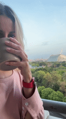 Woman enjoys drink on Valencia balcony Wednesday evening