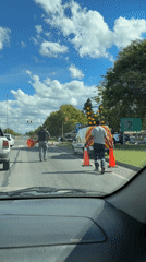 Two men cross street carrying objects in Córdoba