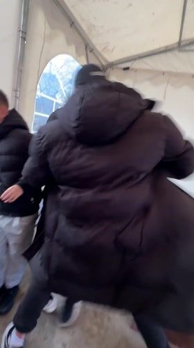 Three people roughhouse in tent structure in Bulgarian village