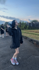 Blue-haired woman walks asphalt path in Kediri, Indonesia