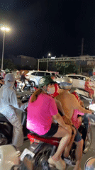 Helmeted motorbike riders wait at Đà Nẵng intersection