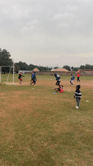 Soccer practice with children watching in Jos, Nigeria