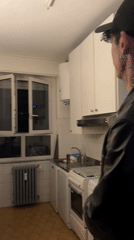 Man celebrates in kitchen amid empty bottles in Milan
