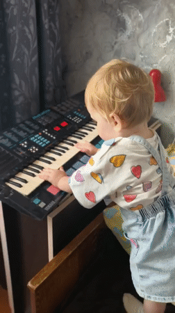 Hands big and small explore a Yamaha keyboard in Sterlitamak
