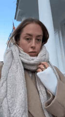 Woman in winter clothing observed outdoors in London sunshine