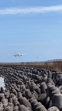 Early morning beach activity captured near Kuta breakwater infrastructure