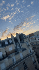 Paris rooftops glow under a warm summer sunset