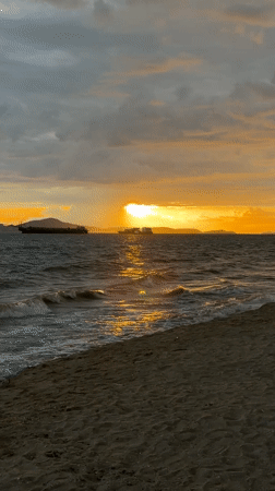 Ocean sunset with waves and distant ships in Pattaya