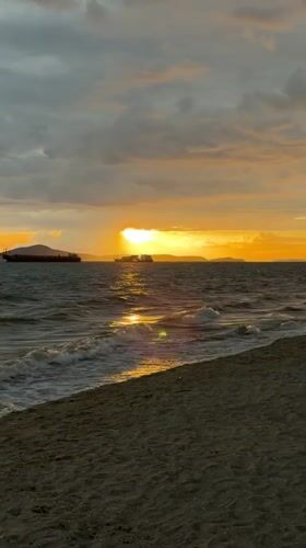 Ocean sunset with waves and distant ships in Pattaya