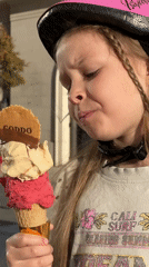 Young girl enjoys large ice cream cone in Tivat