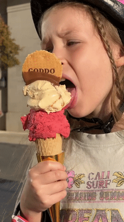 Young girl enjoys large ice cream cone in Tivat