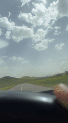 Vehicle travels scenic hillside road in Morocco countryside