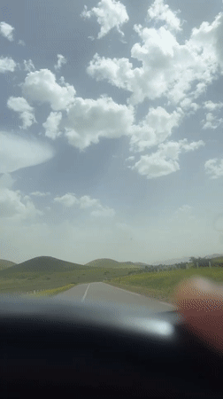 Vehicle travels scenic hillside road in Morocco countryside