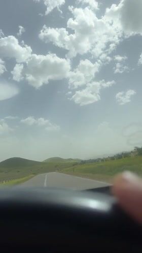 Vehicle travels scenic hillside road in Morocco countryside
