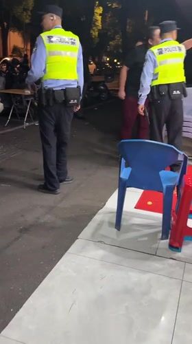 Police officers patrol outdoor commercial area in Shanghai