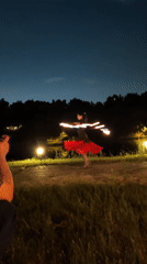 Fire dancer and musicians perform at nighttime gathering in Russia