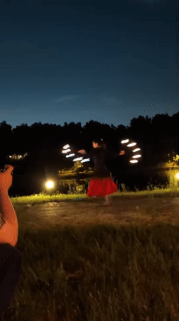 Fire dancer and musicians perform at nighttime gathering in Russia