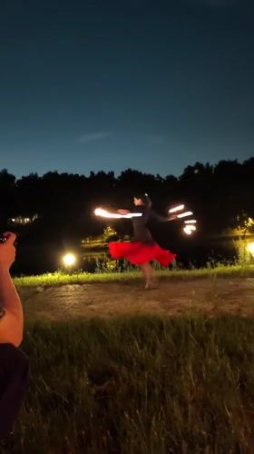 Fire dancer and musicians perform at nighttime gathering in Russia