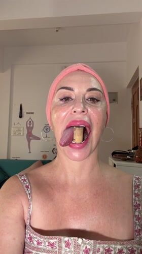 Woman holds wine cork in teeth indoors in Bengaluru